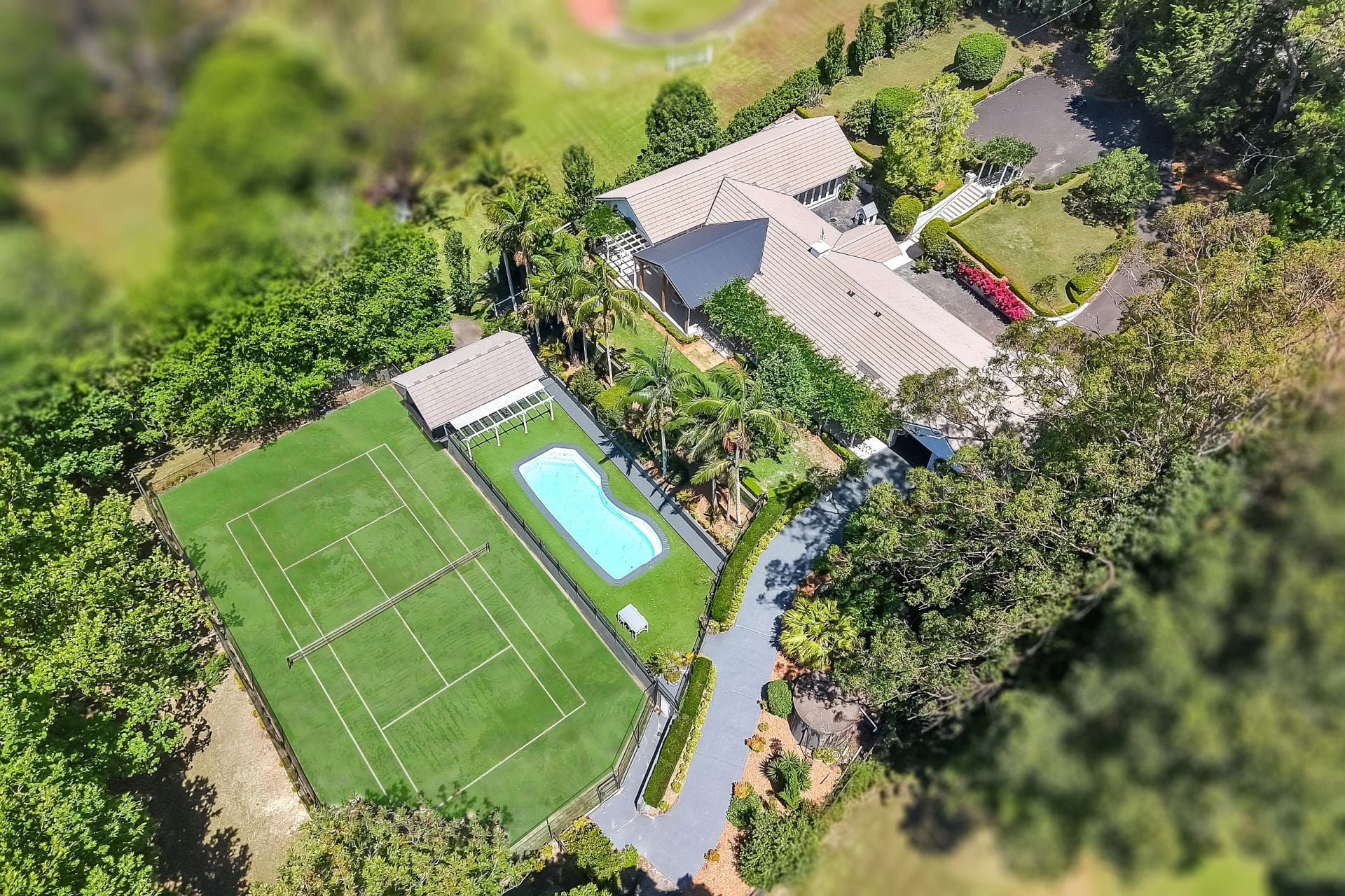 Melody Park aerial — tennis court, pool and outdoor amenities from above